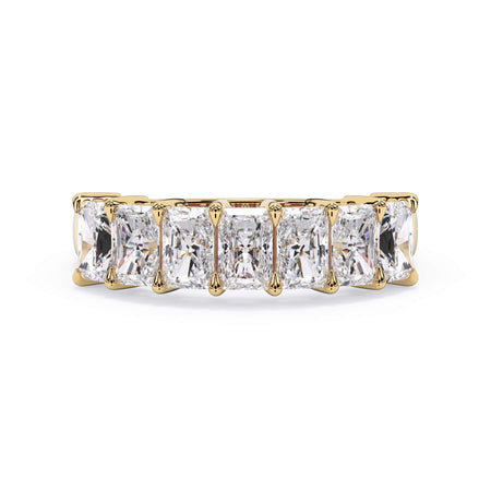 A picture of a seven stone diamond wedding ring with radiant cut diamonds that are shared prong set in yellow gold on a white background with the ring facing forward, lying down.
