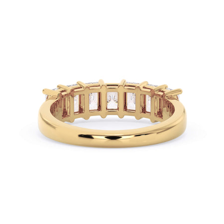 A picture of a seven stone diamond wedding ring with radiant cut diamonds that are shared prong set in yellow gold on a white background with a view of the underside of the ring.