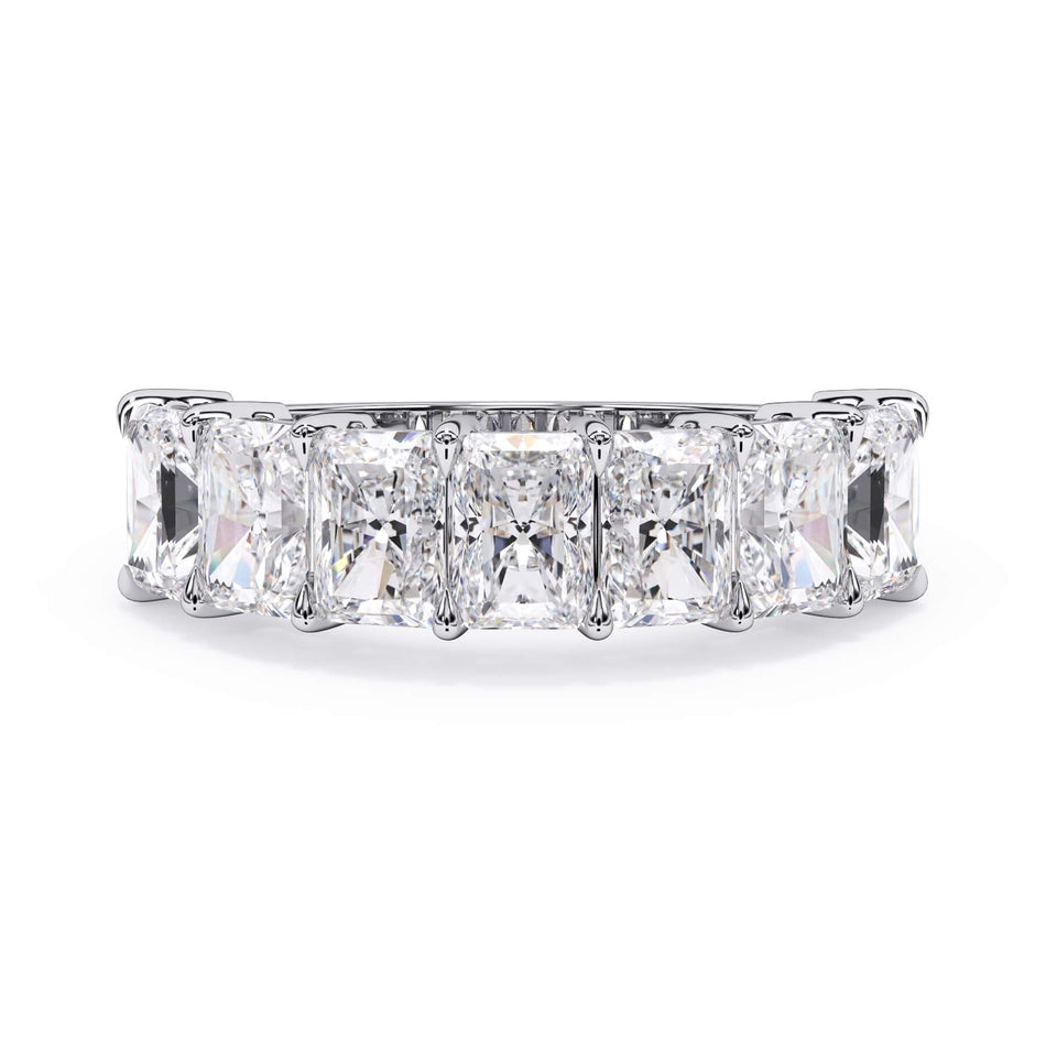 A picture of a seven stone diamond wedding ring with radiant cut diamonds that are shared prong set in white gold or platinum on a white background with the ring facing forward, lying down.