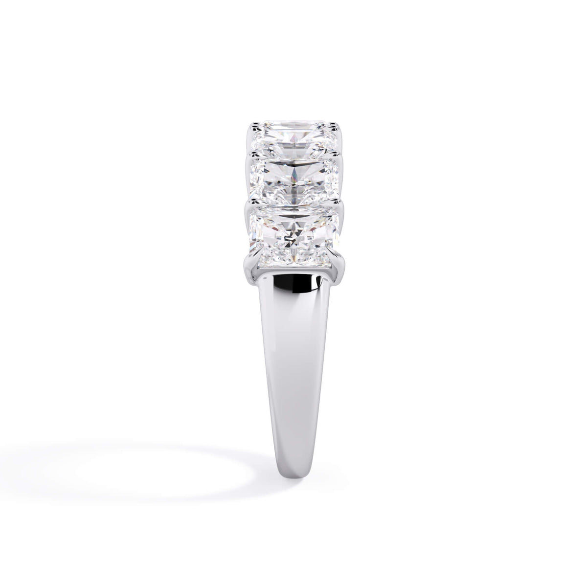 A picture of a seven stone diamond wedding ring with radiant cut diamonds that are shared prong set in white gold or platinum on a white background with a side profile view.