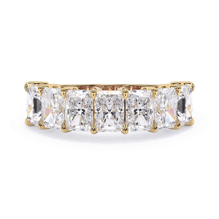 A picture of a seven stone diamond wedding ring with radiant cut diamonds that are shared prong set in yellow gold on a white background with the ring facing forward, lying down.