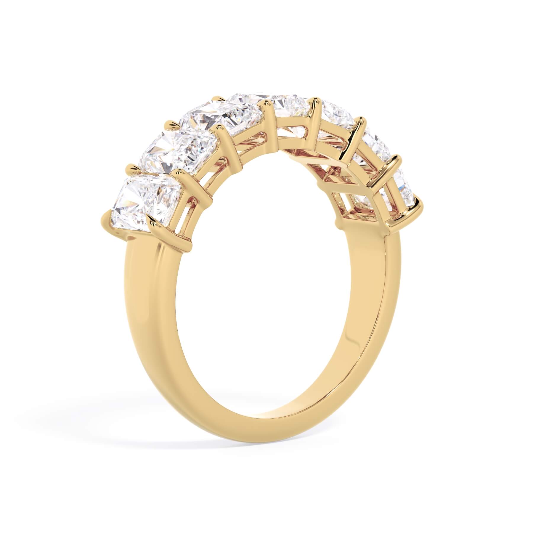 A picture of a seven stone diamond wedding ring with radiant cut diamonds that are shared prong set in yellow gold on a white background with a slightly angled, through the finger view.