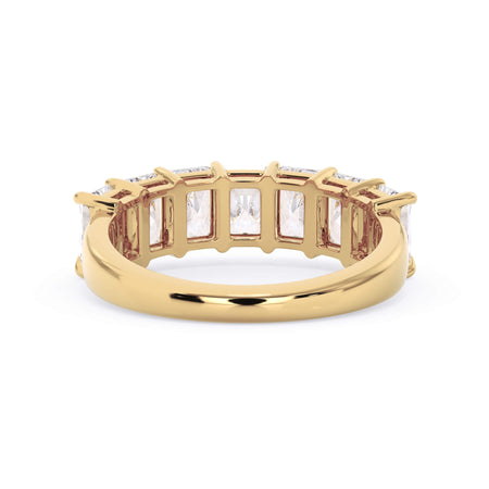 A picture of a seven stone diamond wedding ring with radiant cut diamonds that are shared prong set in yellow gold on a white background with a view of the underside of the ring.