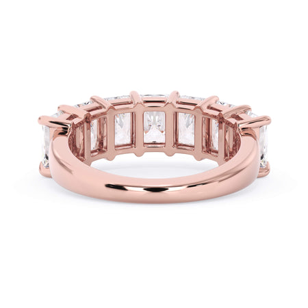 A picture of a seven stone diamond wedding ring with radiant cut diamonds that are shared prong set in rose gold on a white background with a view of the underside of the ring.