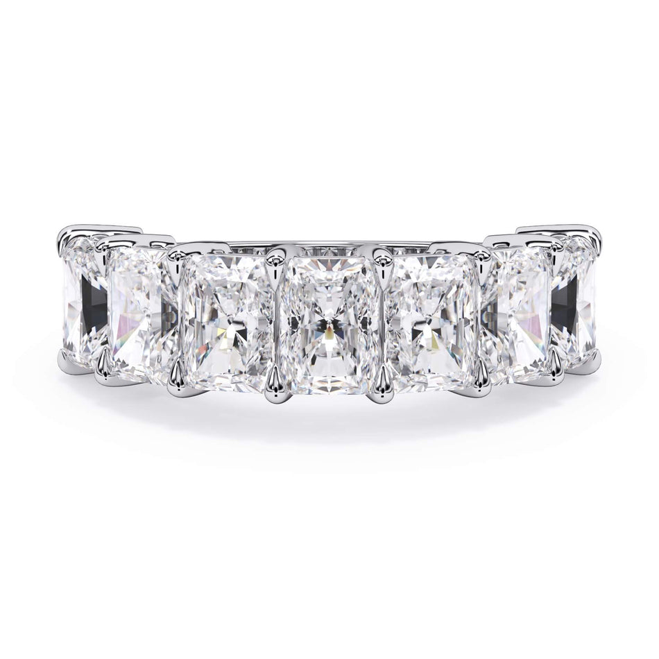 A picture of a seven stone diamond wedding ring with radiant cut diamonds that are shared prong set in white gold or platinum on a white background with the ring facing forward, lying down.