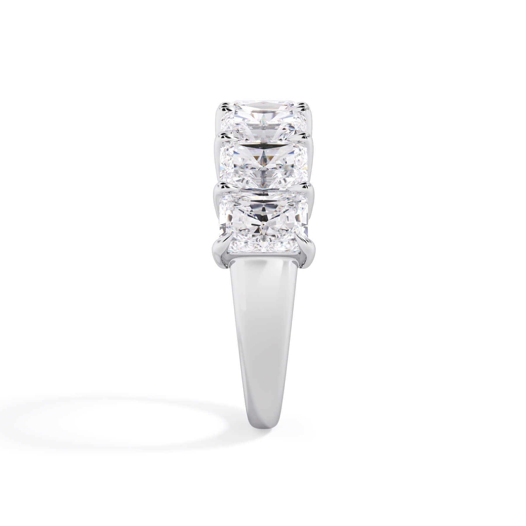 A picture of a seven stone diamond wedding ring with radiant cut diamonds that are shared prong set in white gold or platinum on a white background with a side profile view.