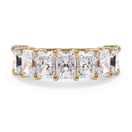 A picture of a seven stone diamond wedding ring with radiant cut diamonds that are shared prong set in yellow gold on a white background with the ring facing forward, lying down.