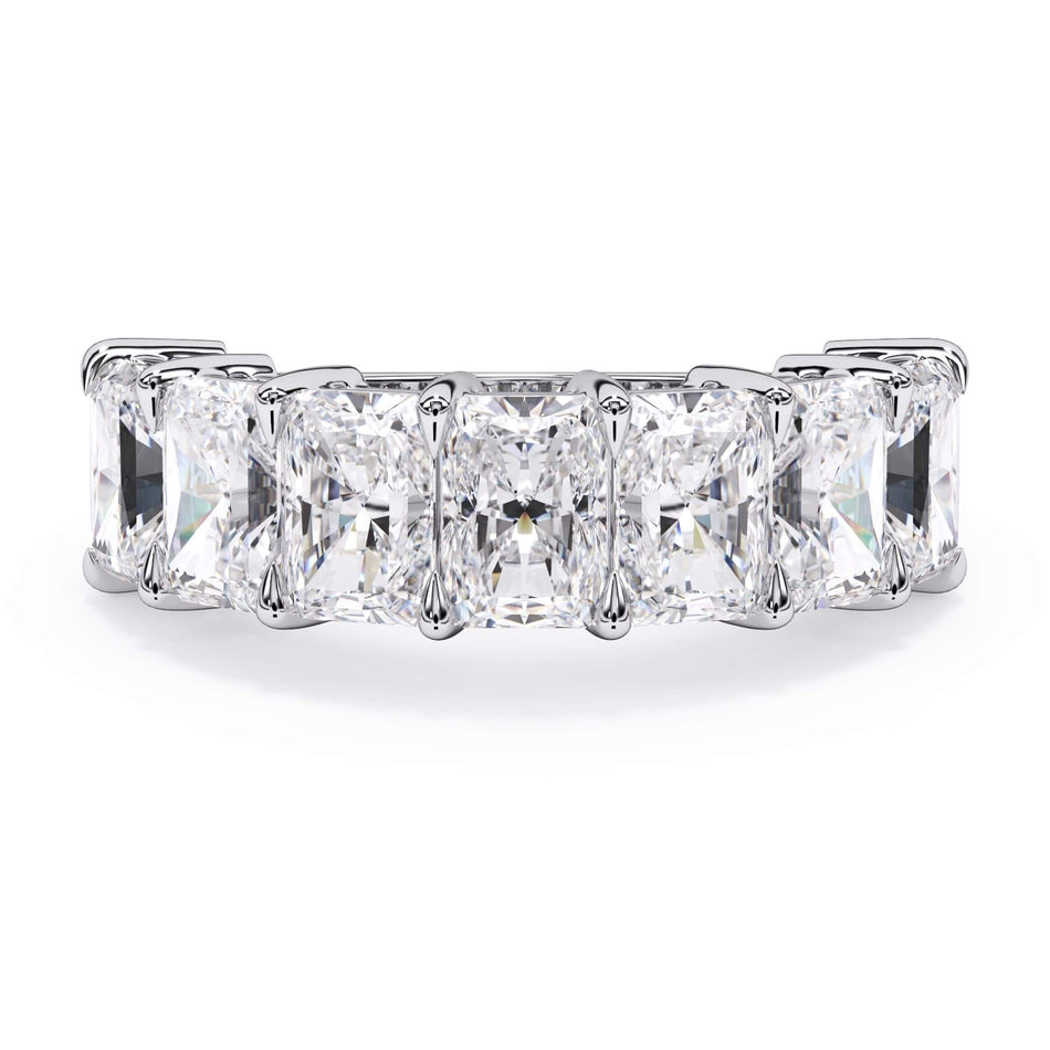 A picture of a seven stone diamond wedding ring with radiant cut diamonds that are shared prong set in white gold or platinum on a white background with the ring facing forward, lying down.