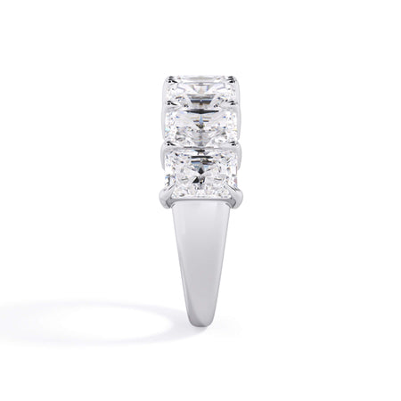 A picture of a seven stone diamond wedding ring with radiant cut diamonds that are shared prong set in white gold or platinum on a white background with a side profile view.