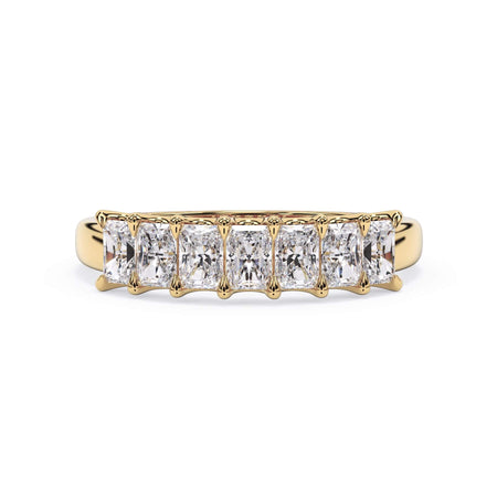 A picture of a seven stone diamond wedding ring with radiant cut diamonds that are U prong set in yellow gold on a white background with the ring facing forward, lying down.