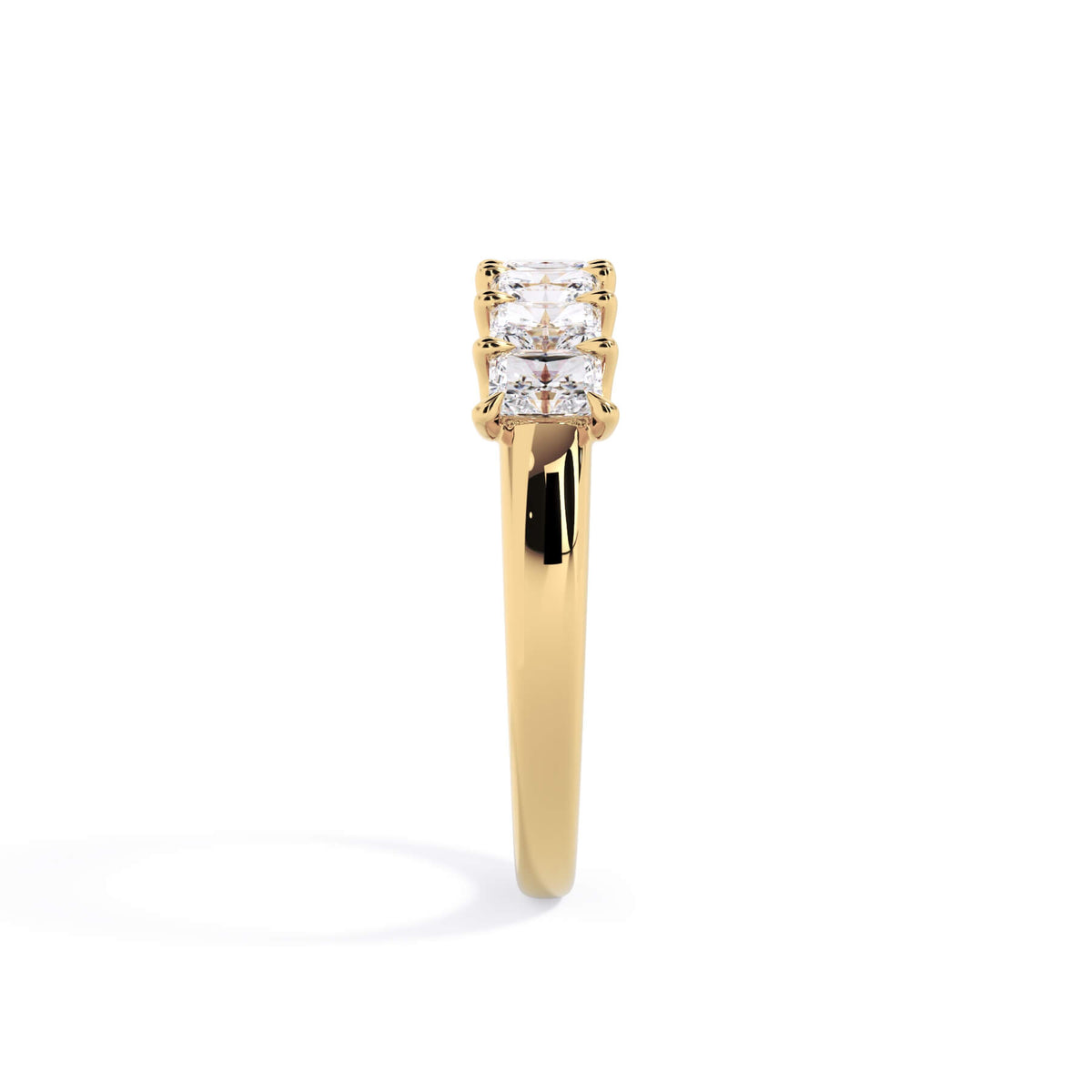 A picture of a seven stone diamond wedding ring with radiant cut diamonds that are U prong set in yellow gold on a white background with a side profile view.