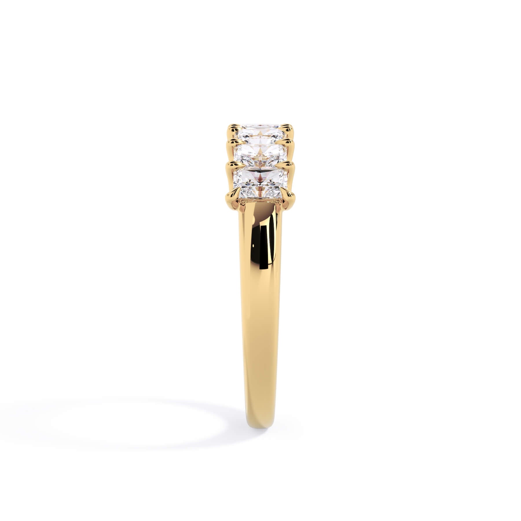 A picture of a seven stone diamond wedding ring with radiant cut diamonds that are U prong set in yellow gold on a white background with a side profile view.