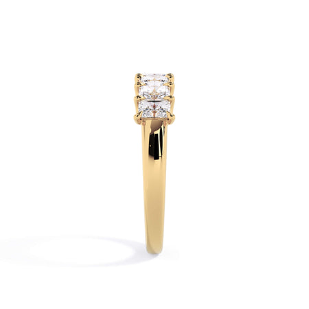 A picture of a seven stone diamond wedding ring with radiant cut diamonds that are U prong set in yellow gold on a white background with a side profile view.