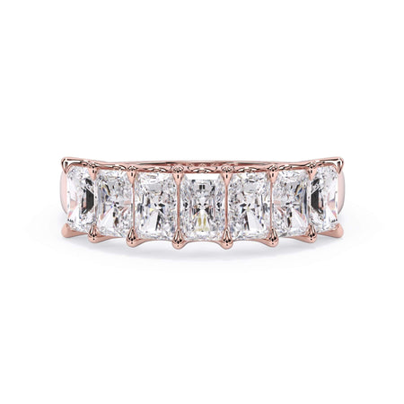 A picture of a seven stone diamond wedding ring with radiant cut diamonds that are U prong set in rose gold on a white background with the ring facing forward, lying down.