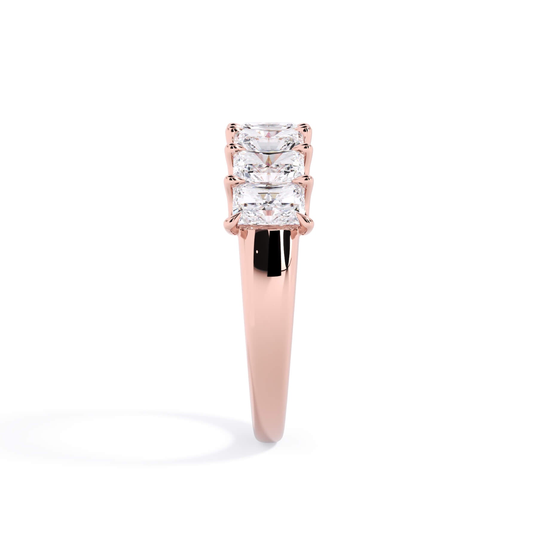 A picture of a seven stone diamond wedding ring with radiant cut diamonds that are U prong set in rose gold on a white background with a side profile view.
