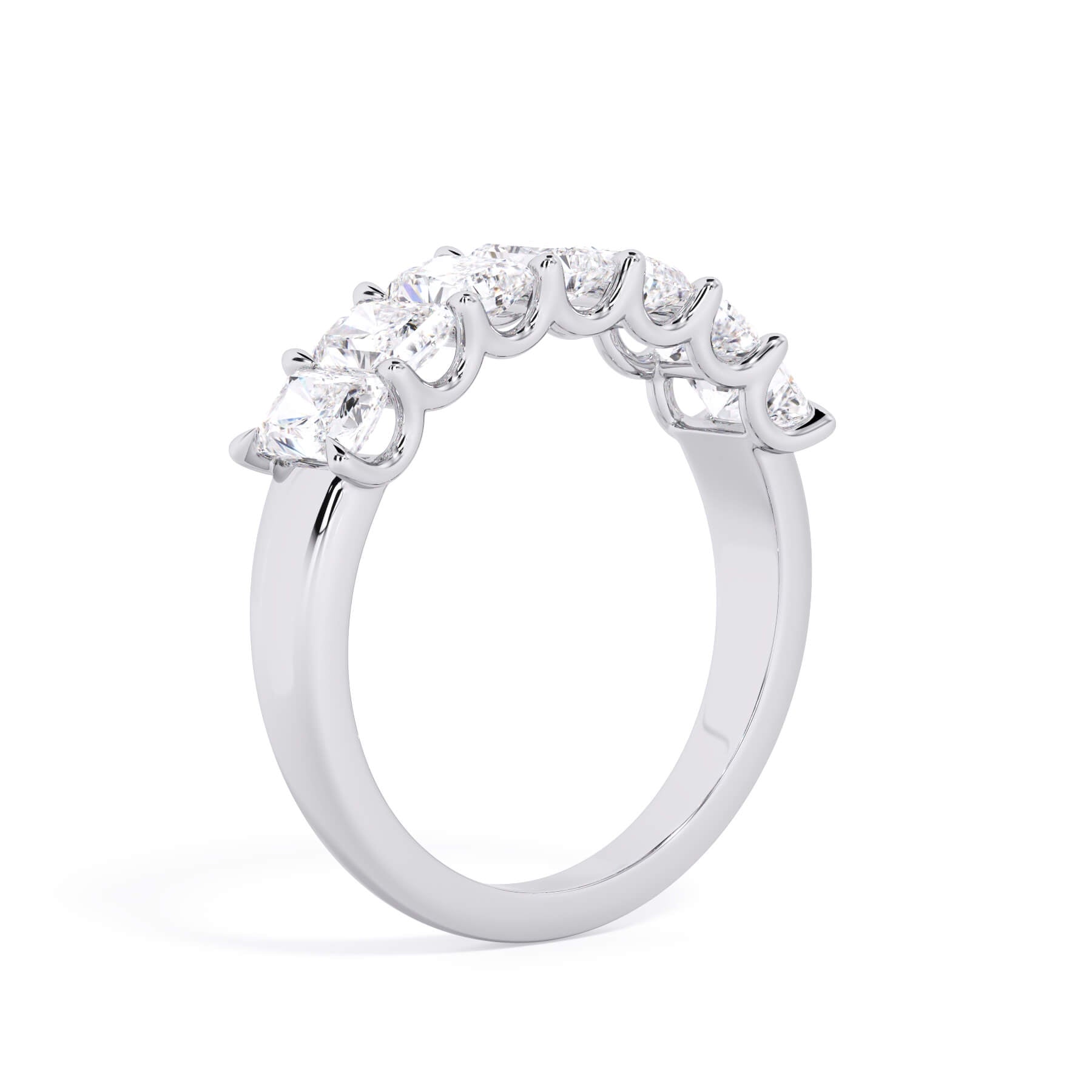 A picture of a seven stone diamond wedding ring with radiant cut diamonds that are U prong set in white gold or platinum on a white background with a slightly angled, through the finger view.