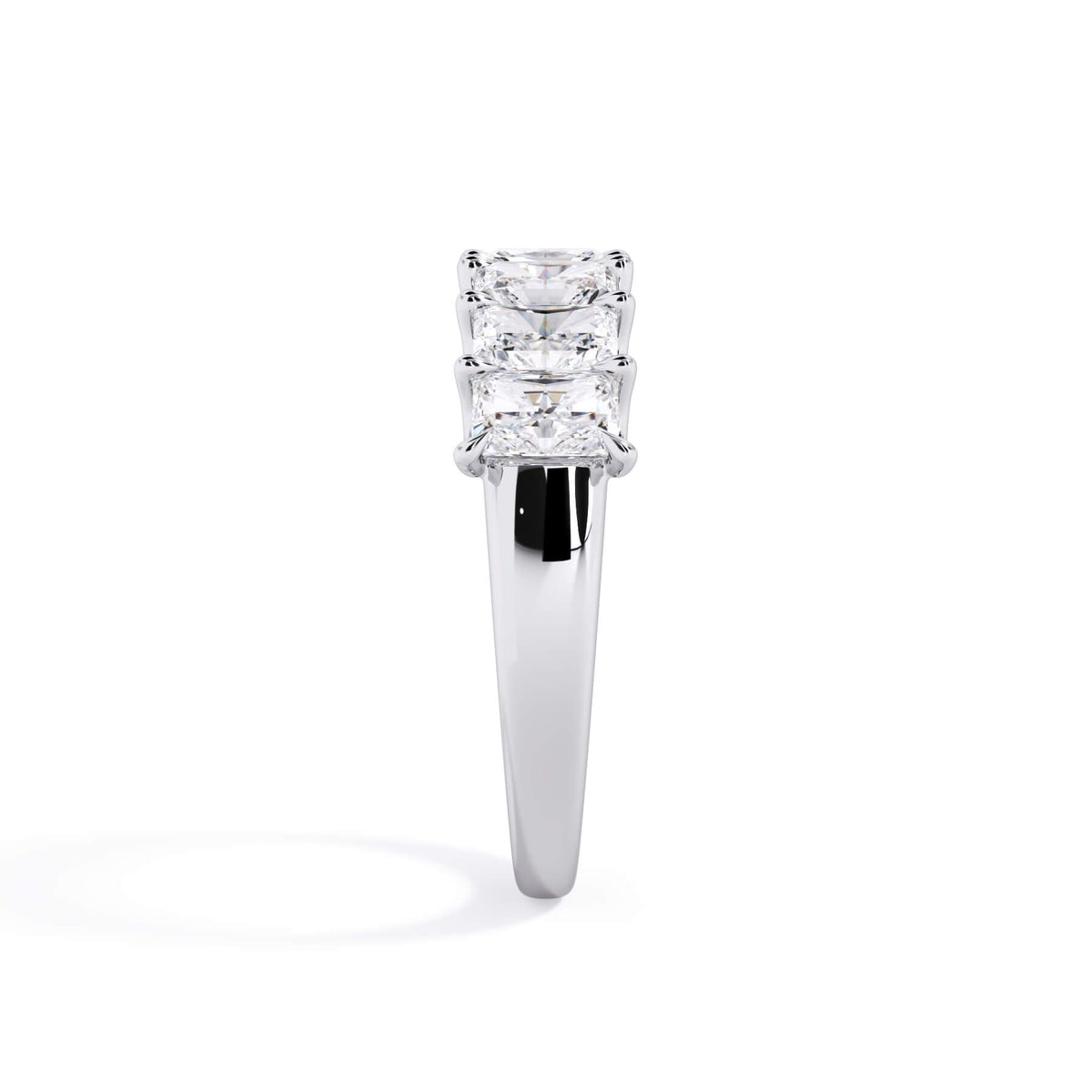 A picture of a seven stone diamond wedding ring with radiant cut diamonds that are U prong set in white gold or platinum on a white background with a side profile view.
