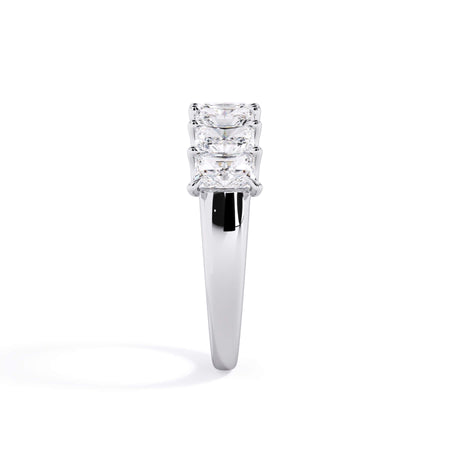 A picture of a seven stone diamond wedding ring with radiant cut diamonds that are U prong set in white gold or platinum on a white background with a side profile view.