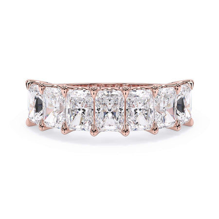 A picture of a seven stone diamond wedding ring with radiant cut diamonds that are U prong set in rose gold on a white background with the ring facing forward, lying down.