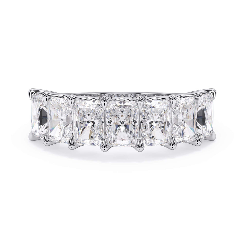 A picture of a seven stone diamond wedding ring with radiant cut diamonds that are U prong set in white gold or platinum on a white background with the ring facing forward, lying down.