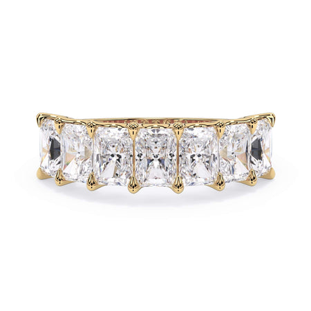 A picture of a seven stone diamond wedding ring with radiant cut diamonds that are U prong set in yellow gold on a white background with the ring facing forward, lying down.