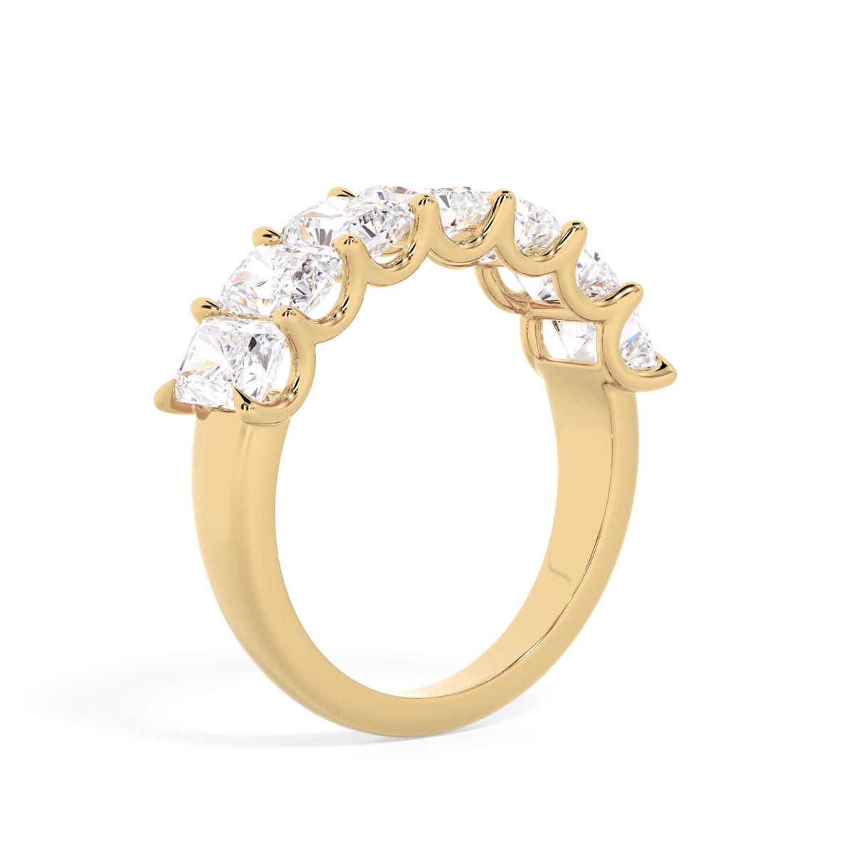 A picture of a seven stone diamond wedding ring with radiant cut diamonds that are U prong set in yellow gold on a white background with a slightly angled, through the finger view.