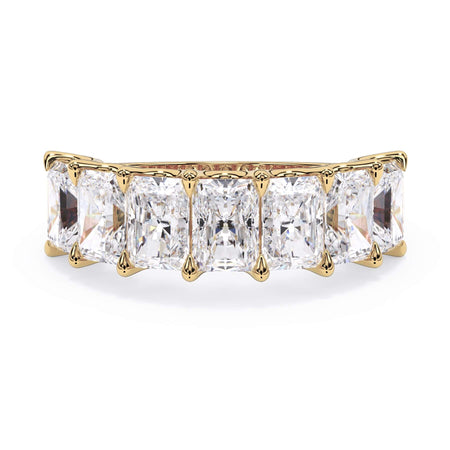 A picture of a seven stone diamond wedding ring with radiant cut diamonds that are U prong set in yellow gold on a white background with the ring facing forward, lying down.