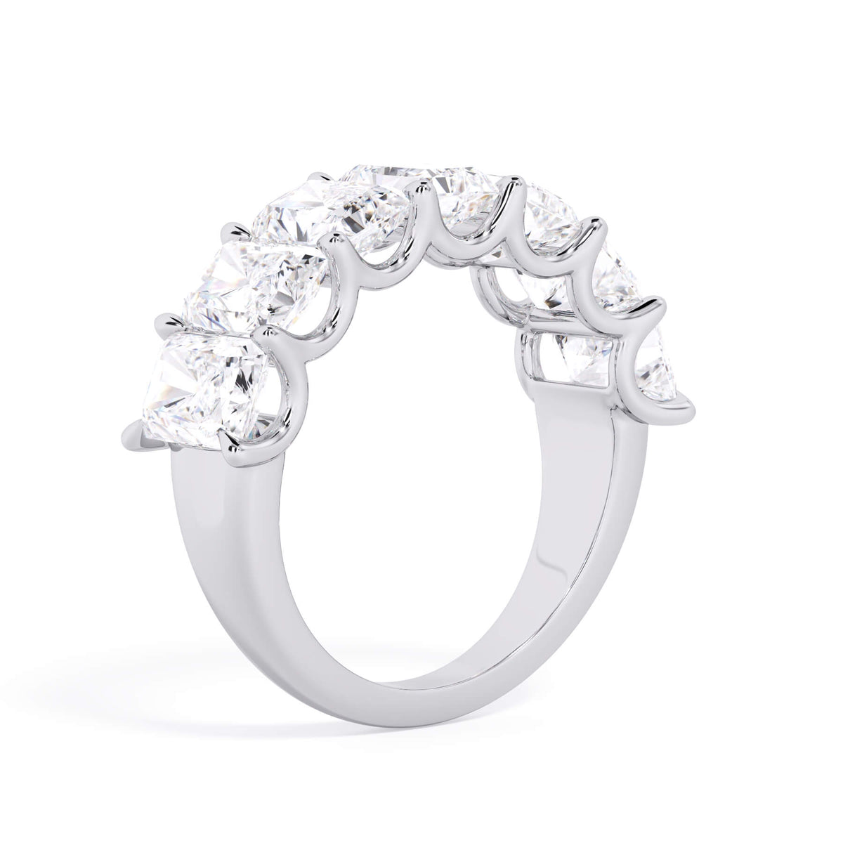 A picture of a seven stone diamond wedding ring with radiant cut diamonds that are U prong set in white gold or platinum on a white background with a slightly angled, through the finger view.
