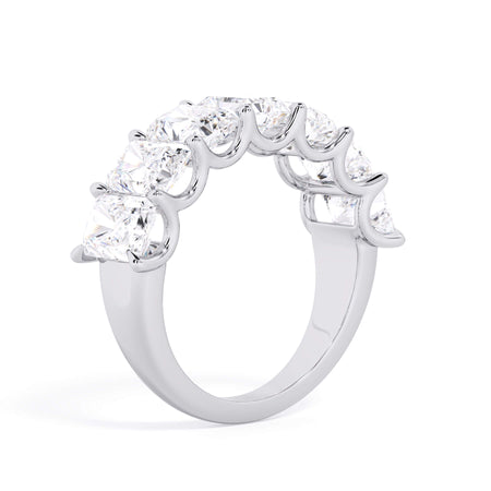 A picture of a seven stone diamond wedding ring with radiant cut diamonds that are U prong set in white gold or platinum on a white background with a slightly angled, through the finger view.