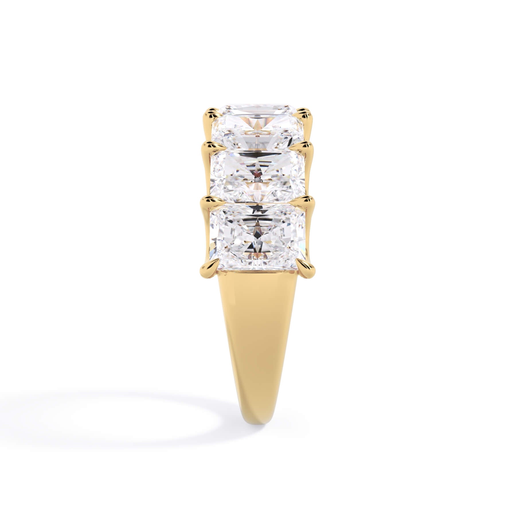 A picture of a seven stone diamond wedding ring with radiant cut diamonds that are U prong set in yellow gold on a white background with a side profile view.