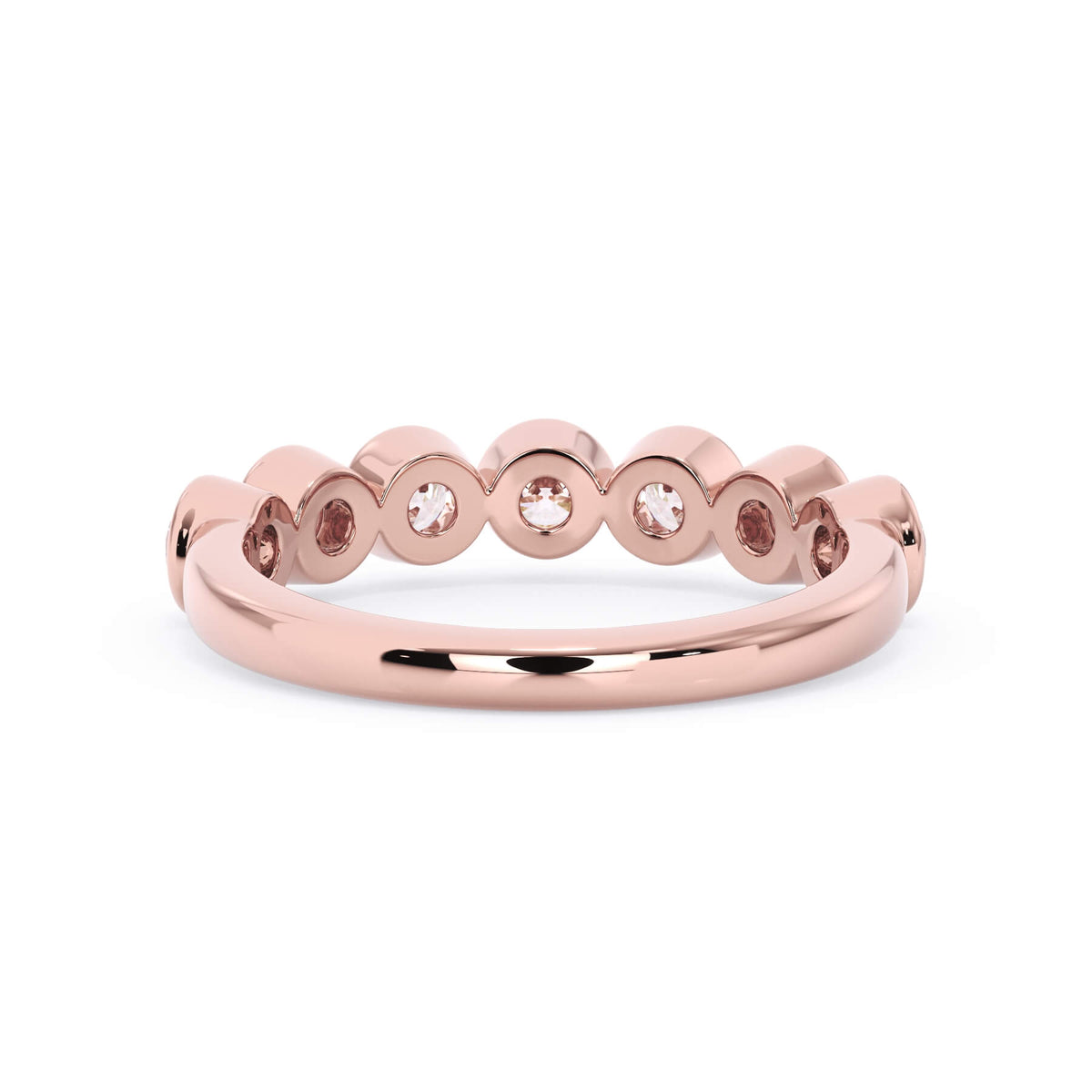 A picture of a seven stone diamond wedding ring with round diamonds that are bezel set in rose gold on a white background with a view of the underside of the ring.