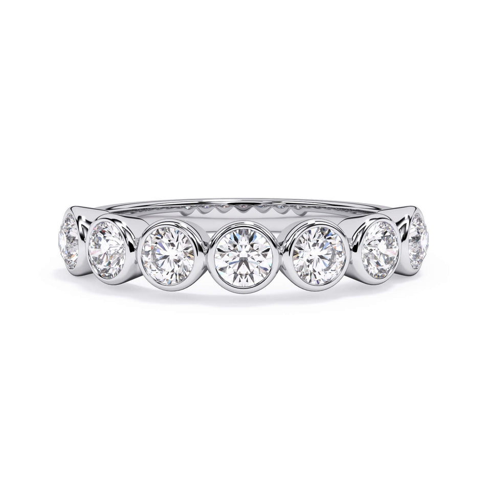 A picture of a seven stone diamond wedding ring with round diamonds that are bezel set in white gold or platinum on a white background with the ring facing forward, lying down.
