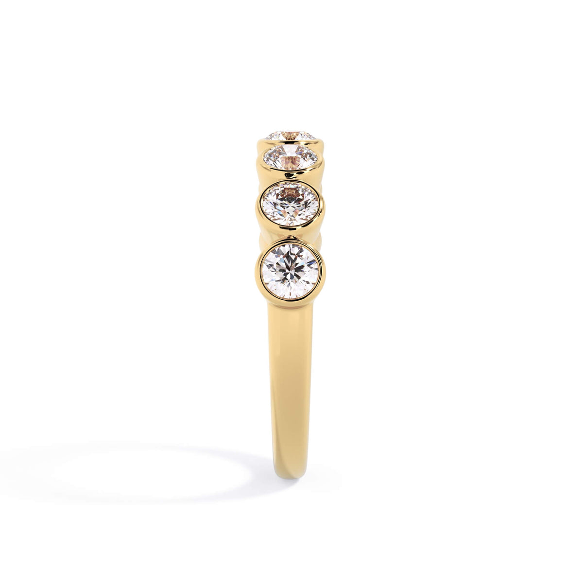 A picture of a seven stone diamond wedding ring with round diamonds that are bezel set in yellow gold on a white background with a side profile view.
