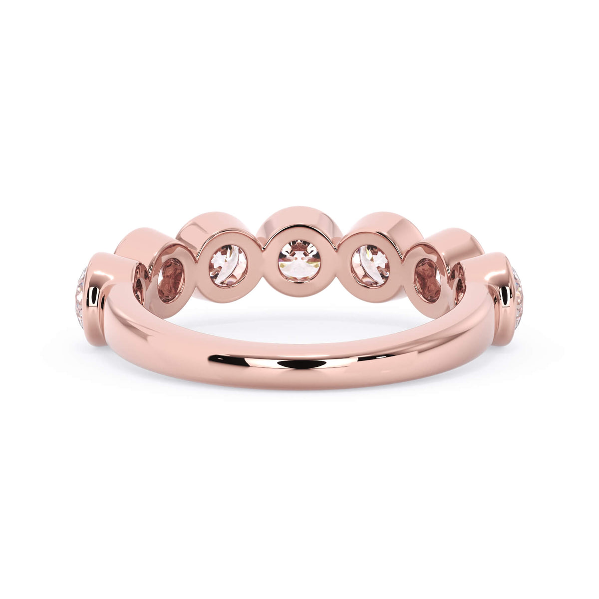 A picture of a seven stone diamond wedding ring with round diamonds that are bezel set in rose gold on a white background with a view of the underside of the ring.
