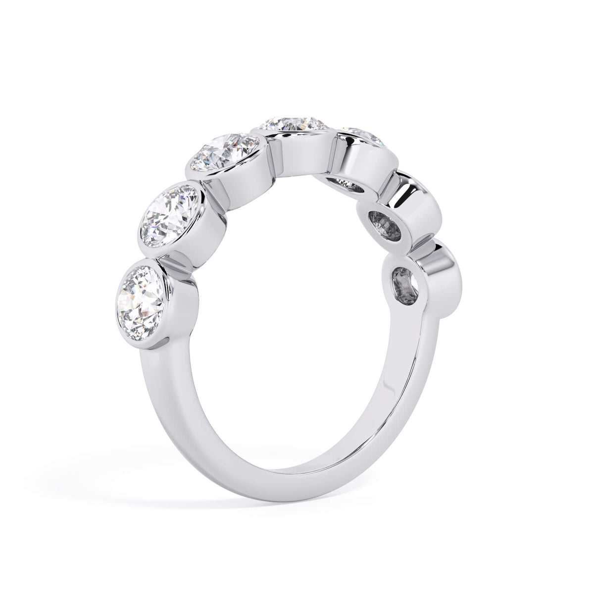 A picture of a seven stone diamond wedding ring with round diamonds that are bezel set in white gold or platinum on a white background with a slightly angled, through the finger view.