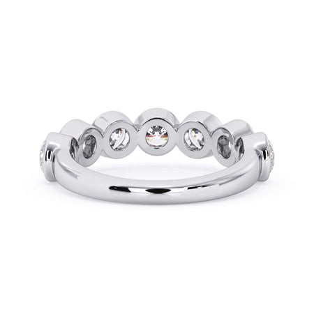 A picture of a seven stone diamond wedding ring with round diamonds that are bezel set in white gold or platinum on a white background with a view of the underside of the ring.