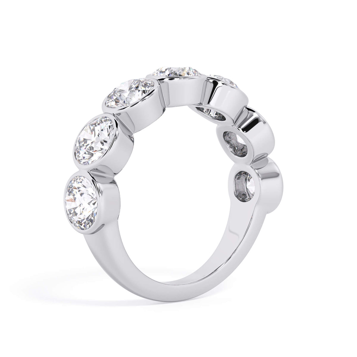 A picture of a seven stone diamond wedding ring with round diamonds that are bezel set in white gold or platinum on a white background with a slightly angled, through the finger view.