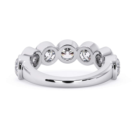 A picture of a seven stone diamond wedding ring with round diamonds that are bezel set in white gold or platinum on a white background with a view of the underside of the ring.