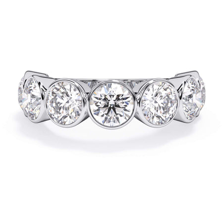 A picture of a seven stone diamond wedding ring with round diamonds that are bezel set in white gold or platinum on a white background with the ring facing forward, lying down.
