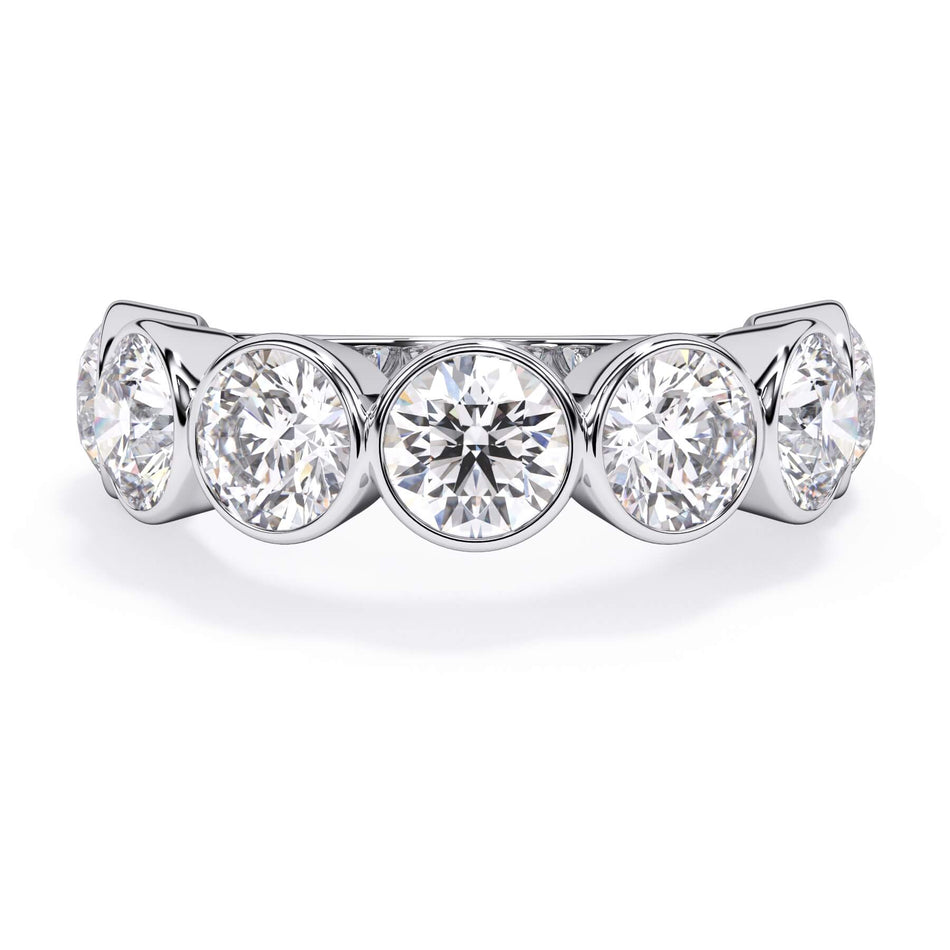 A picture of a seven stone diamond wedding ring with round diamonds that are bezel set in white gold or platinum on a white background with the ring facing forward, lying down.