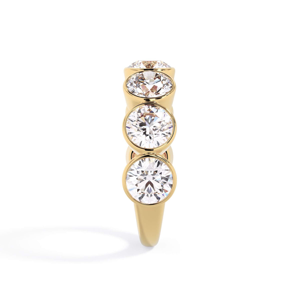 A picture of a seven stone diamond wedding ring with round diamonds that are bezel set in yellow gold on a white background with a side profile view.