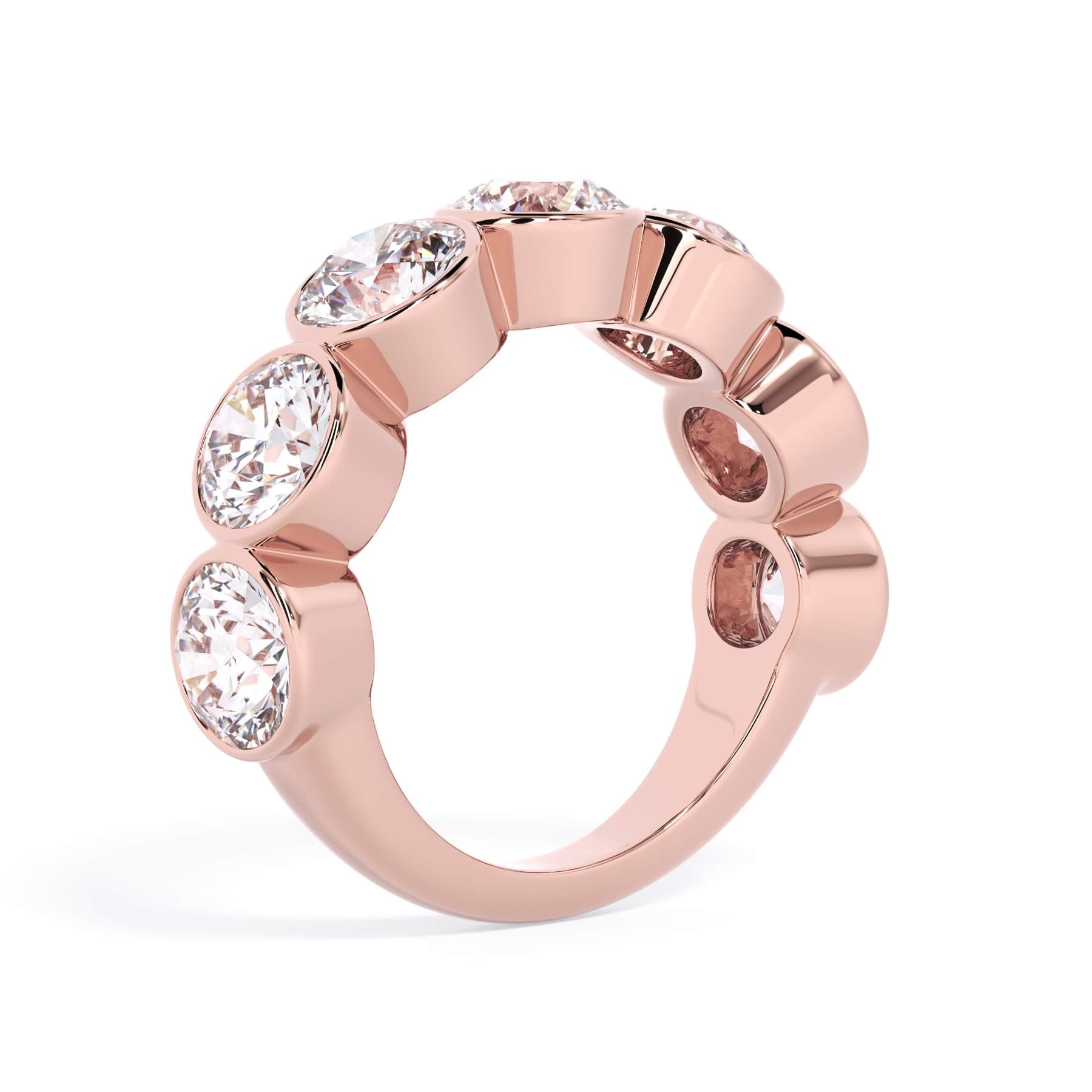 A picture of a seven stone diamond wedding ring with round diamonds that are bezel set in rose gold on a white background with a slightly angled, through the finger view.