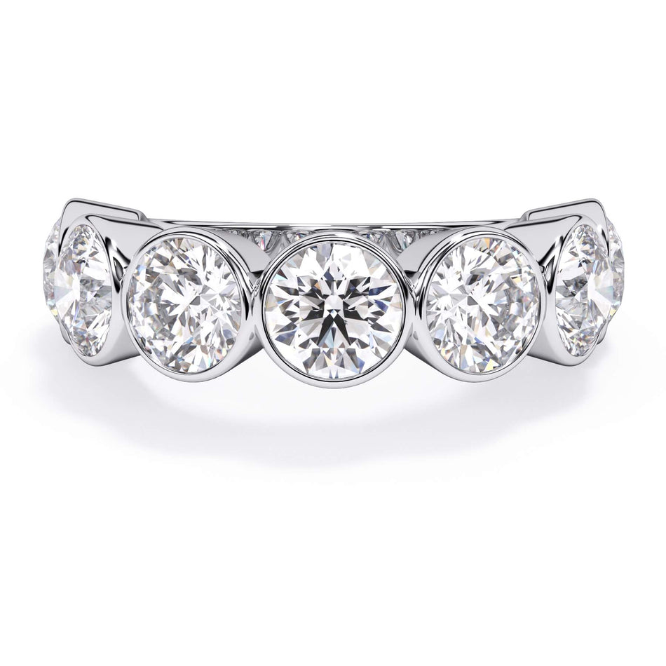 A picture of a seven stone diamond wedding ring with round diamonds that are bezel set in white gold or platinum on a white background with the ring facing forward, lying down.