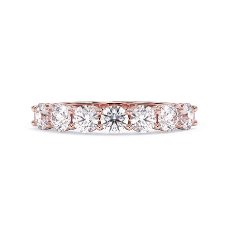 A picture of a seven stone diamond wedding ring with round diamonds that are shared prong set in rose gold on a white background with the ring facing forward, lying down.