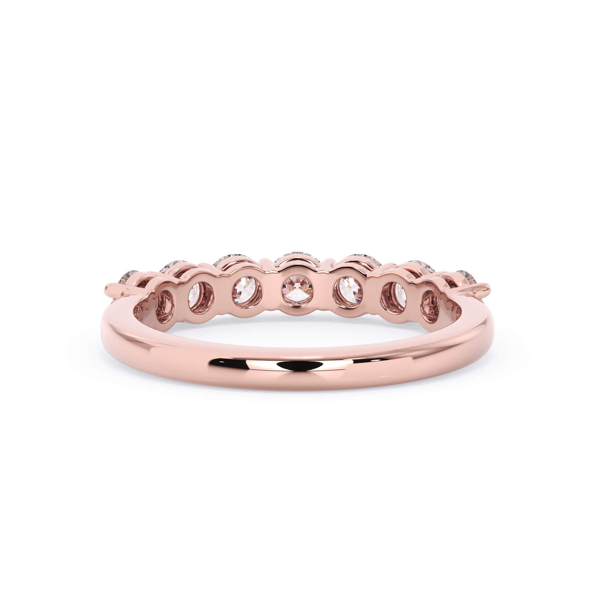 A picture of a seven stone diamond wedding ring with round diamonds that are shared prong set in rose gold on a white background with a view of the underside of the ring.