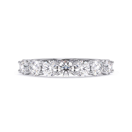 A picture of a seven stone diamond wedding ring with round diamonds that are shared prong set in white gold or platinum on a white background with the ring facing forward, lying down.
