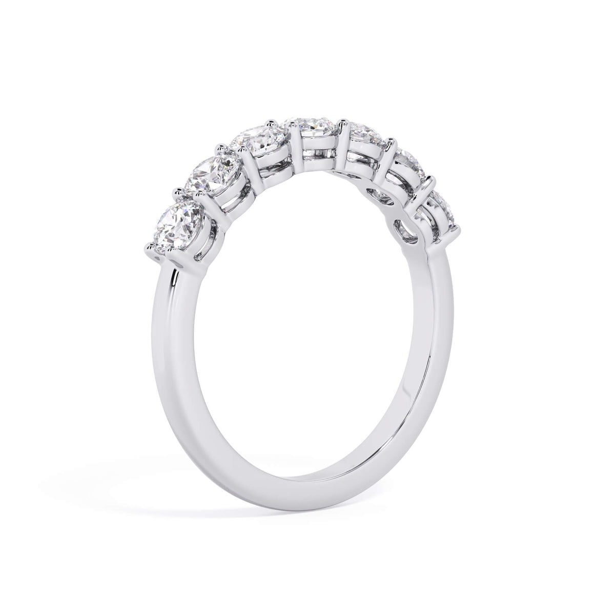 A picture of a seven stone diamond wedding ring with round diamonds that are shared prong set in white gold or platinum on a white background with a slightly angled, through the finger view.