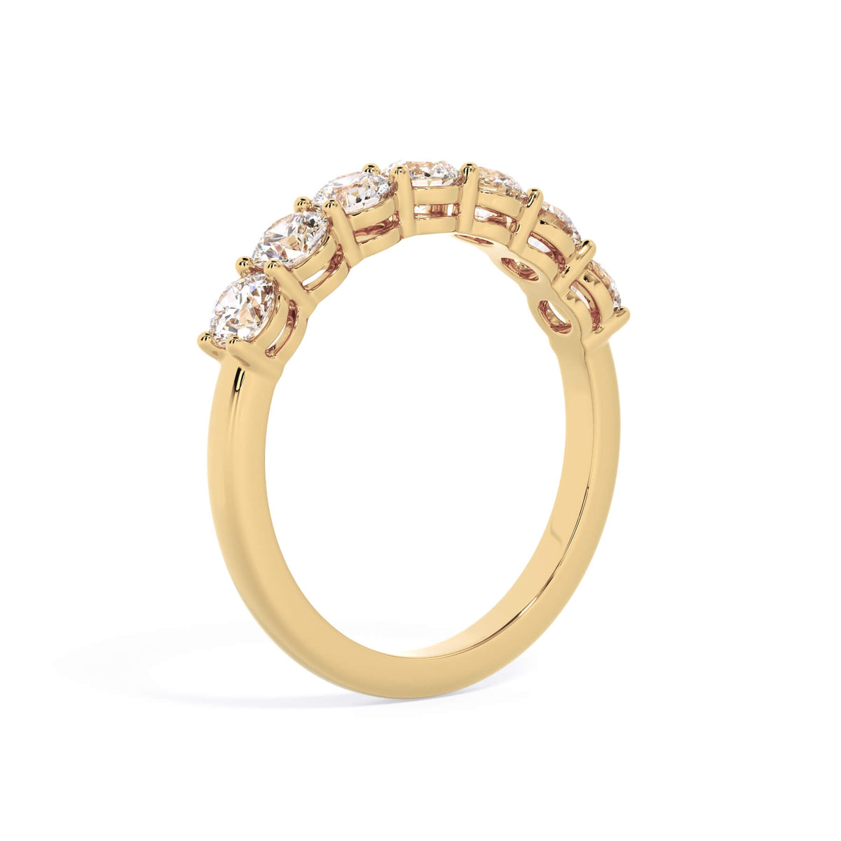 A picture of a seven stone diamond wedding ring with round diamonds that are shared prong set in yellow gold on a white background with a slightly angled, through the finger view.