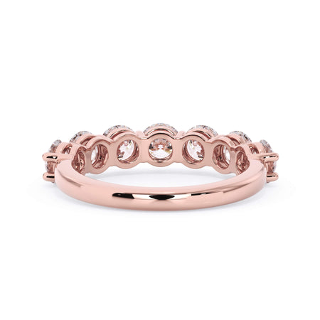 A picture of a seven stone diamond wedding ring with round diamonds that are shared prong set in rose gold on a white background with a view of the underside of the ring.