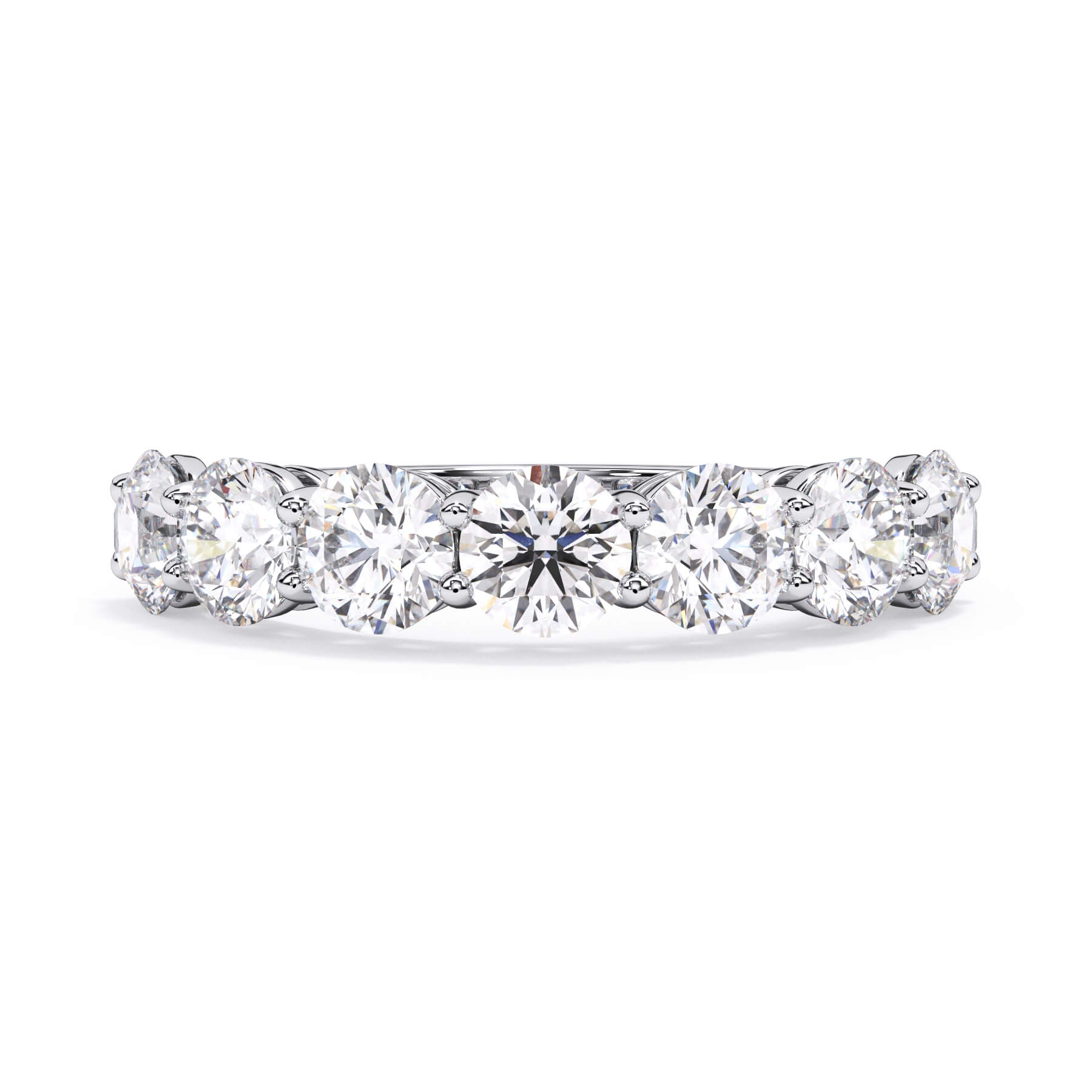 A picture of a seven stone diamond wedding ring with round diamonds that are shared prong set in white gold or platinum on a white background with the ring facing forward, lying down.